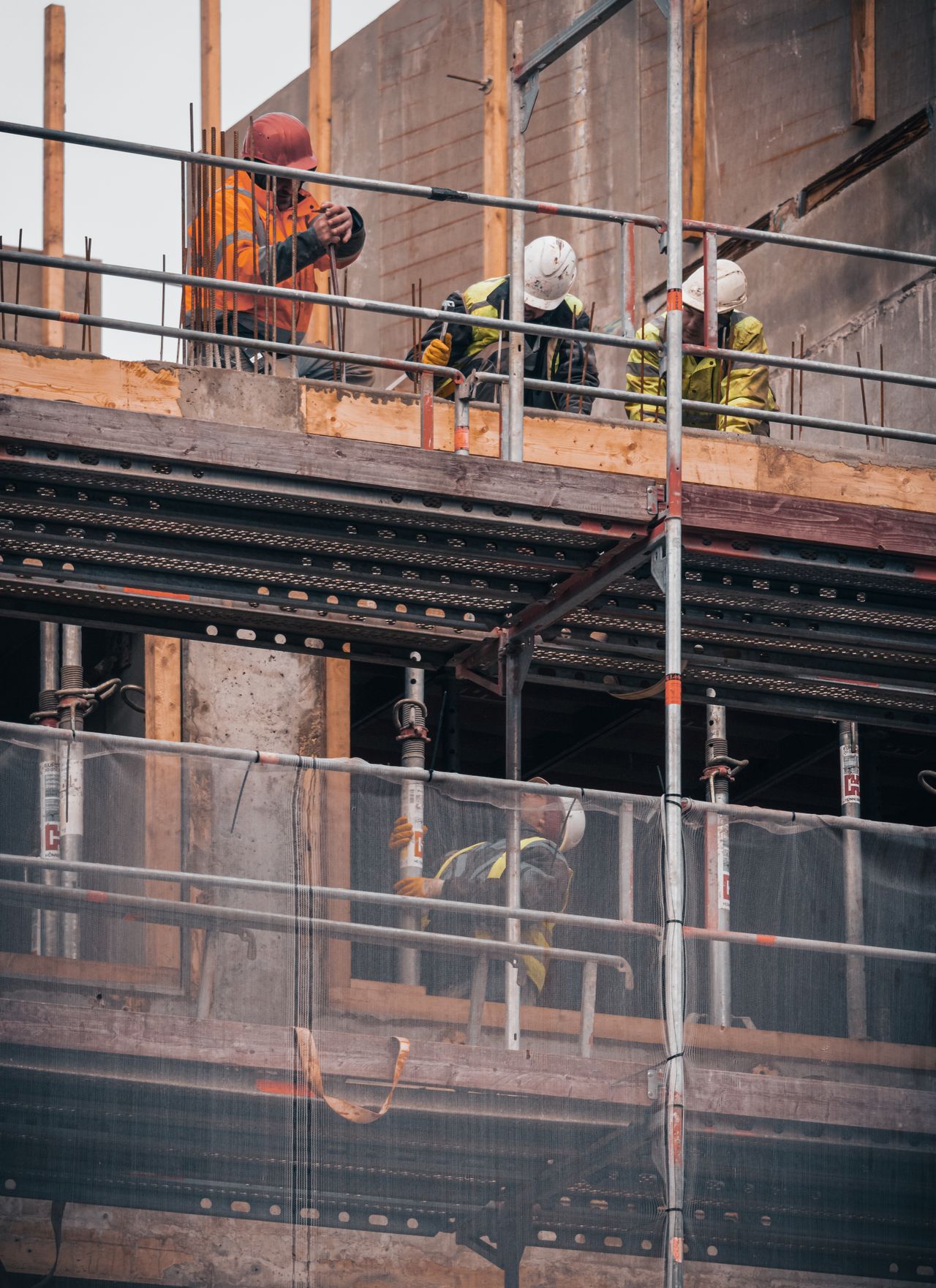 Trabalhadores da construção civil com EPIs em canteiro de obra residencial