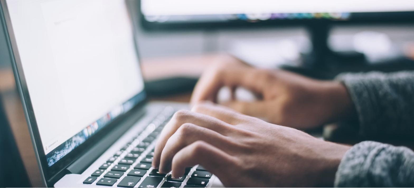 Mãos digitando em notebook, representando o preenchimento de eventos no eSocial